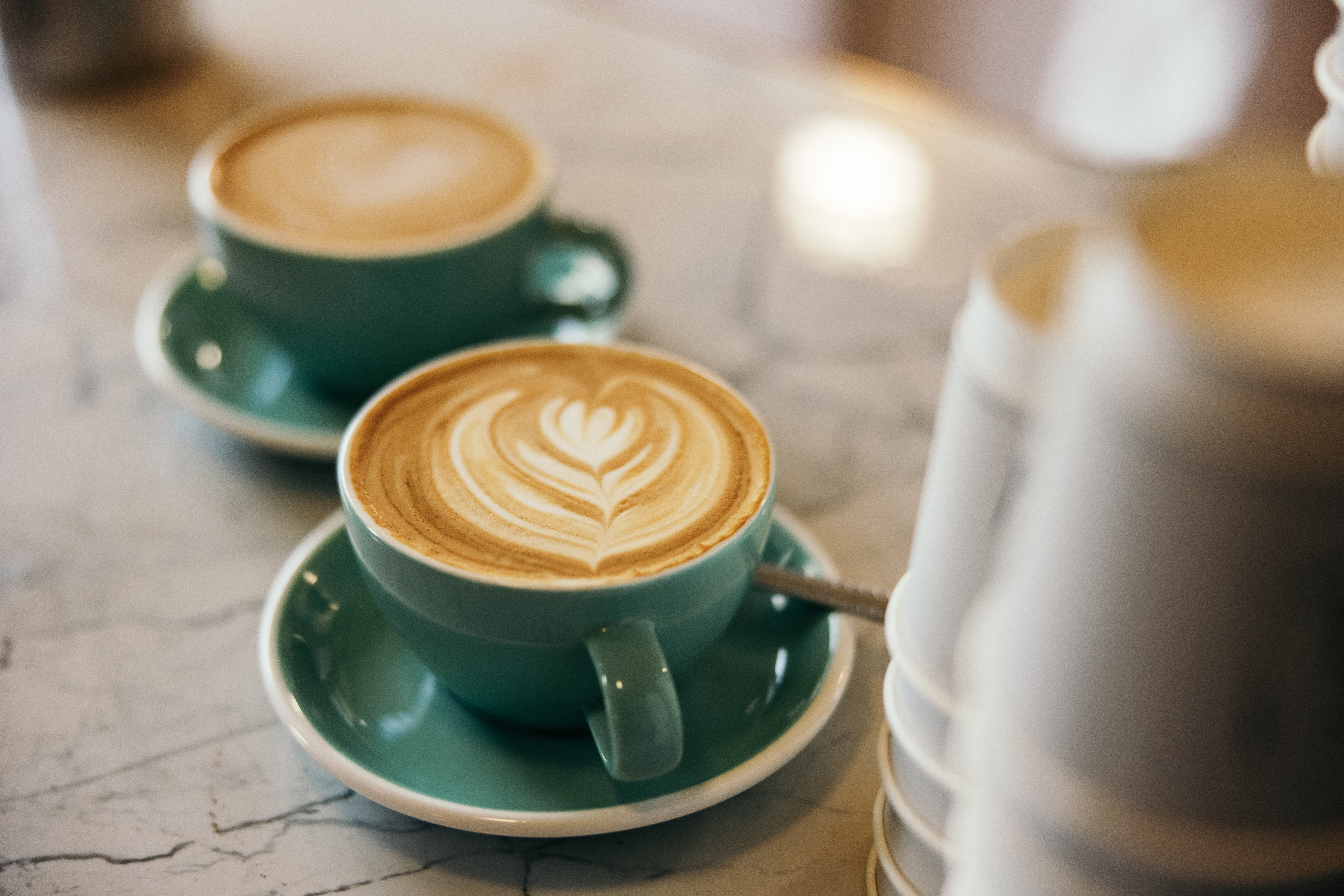 Two cups of coffee, ready to serve at the counter.
